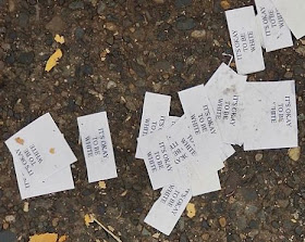 Photo showing slips of paper on the ground, with printed text, "It's okay to be white"