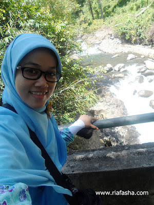 berfoto di atas jembatan melihat air terjun kemumu