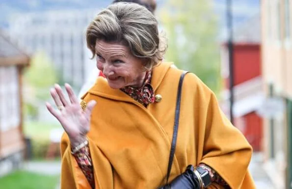 King Harald of Norway was hospitalized. Queen Sonja wore a pussy-bow floral-print stretch-crepe blouse, and yellow vest, and brown trousers