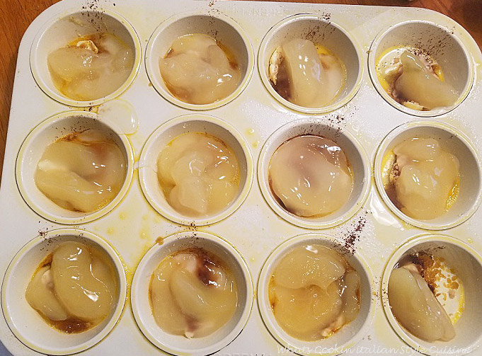Apple Cake Cups this is a muffin tin with apples and butter on the bottom then a layer of homemade cake batter on top getting ready to be baked in the oven