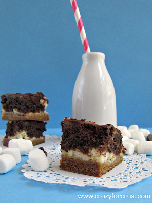 S'mores brownie cheesecake bars on a white doily with title