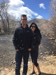 man and woman standing beside a river