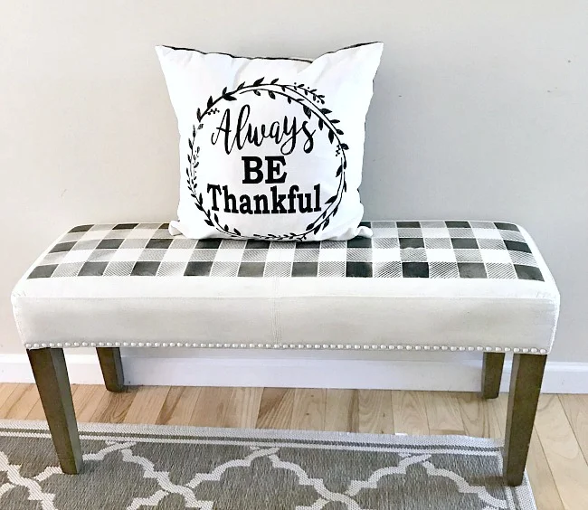 A painted fabric bench with a buffalo plaid stencil