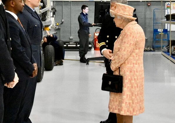 As Honorary Air Commodore, Queen Elizabeth. She wearing a peaches and cream outfit with matching hat by Angela Kelly. diamond bow brooch
