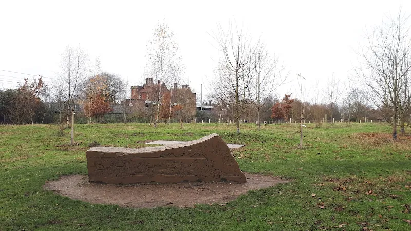 Another sculpture alongside the trail with Needham MArket station building in the backgrouud