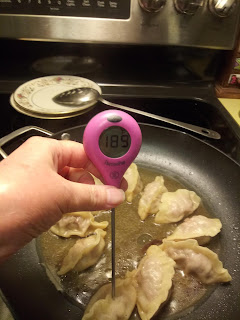 Potstickers being checked with digital thermometer inserted in center