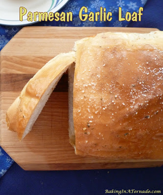 Parmesan Garlic Loaf is an easy compliment to any meal. This crusty loaf is filled with swirls of garlic and herb butter and parmesan cheese. | Recipe developed by www.BakingInATornado.com | #recipe #bread