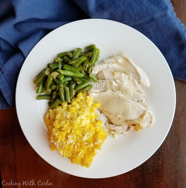 This vintage recipe is a hearty filling side dish that was a staple at many family dinners of my childhood and those of the generations before me. Great-grandma's scalloped corn is a perfect side to so many dinner entrees! dinner plate with turkey, gravy, green beans and scalloped corn