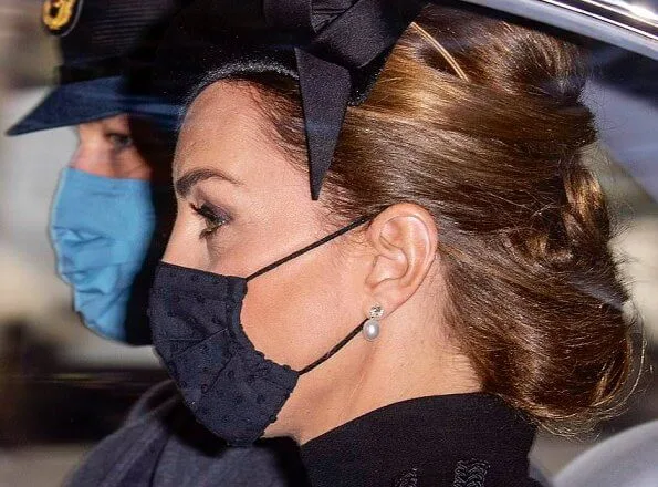 Kate Middleton wore a bespoke black military coat by Alexander McQueen, and a Philip Treacy hat. Queen's diamond and pearl earrings