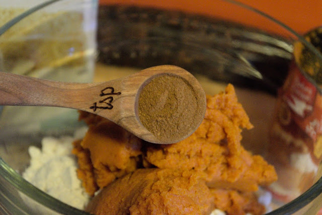 Pumpkin pie spice being added to the mixing bowl. 