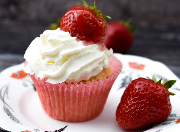close up of strawberry and cream muffin on a square floral teaplate