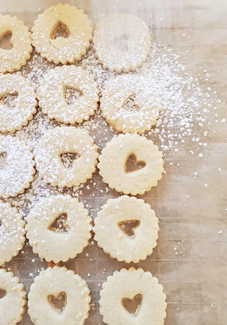 dustingplate of valentine heart linzer cookies with confectioners sugar