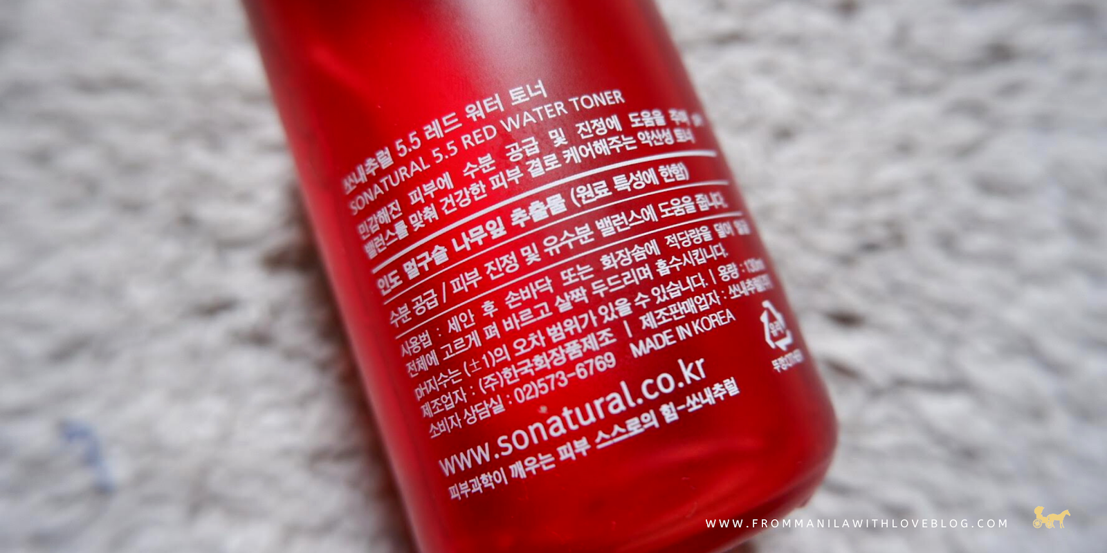 an image of a red matte glass bottle with korean ingredients on it placed on a rug