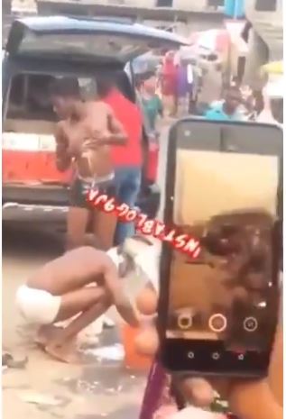 Suspected Yahoo Boys Seen Taking Their Bath In The Middle Of A Market In Lagos (Video)