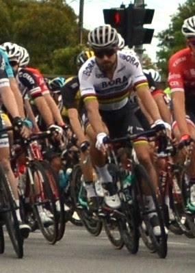 Front-on close-up view of Peter Sagan riding in the front ranks of the peloton.