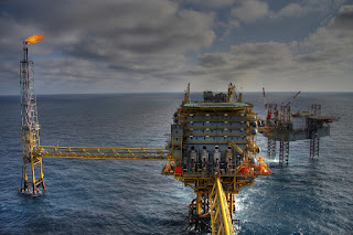 A landscape photograph of an oil drilling platform in the deep ocean