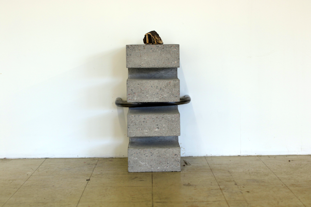 a sculpture on the floor, reaching knee-height, made of bronze, concrete and steel. Description in text. a sculpture on the floor, reaching knee-height, made of bronze, concrete and steel. Description in text.