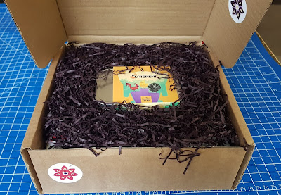 The Dark Imp Buzzlebox Unboxing Review Top contents shows shredded paper and a tin containing a game
