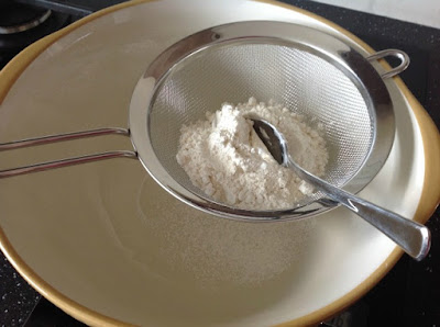 sieve over bowl full of flour