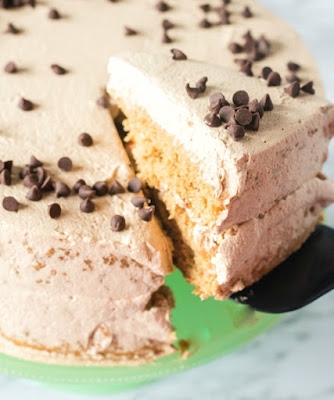 Layers of coffee infused sponge cake wrapped in a fluffy mocha whipped cream, this cake is a coffee lover's dream come true! Coffee and cream sponge cake is a grown up dessert that is sure to impress. first slice of coffee and cream sponge cake being removed from cake