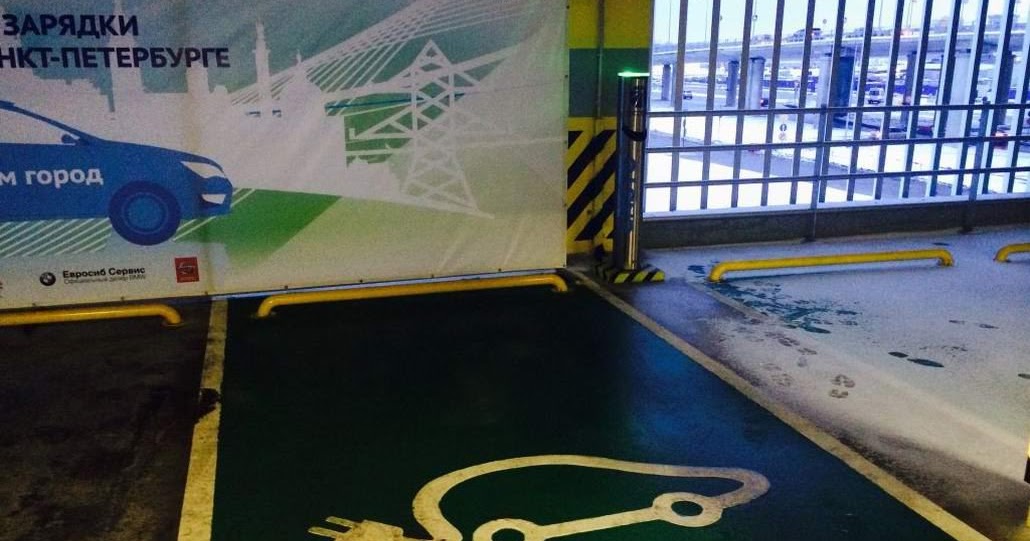 Зарядная станция для электромобиля в паркинге. Зарядные станции для электромобилей на подземной парковке. Разметка парковки для электромобилей. Парковка для электромобилей. Станция зарядки электромобилей.