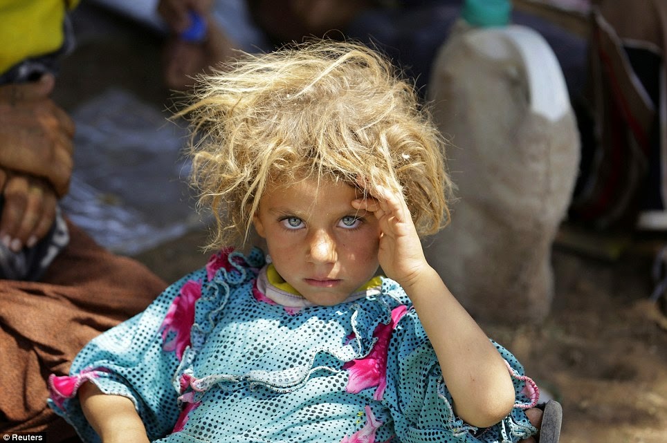 A GIRL FROM THE MINORITY YAZIDI SECT RESTS AT THE IRAQI-SYRIAN BORDER CROSSING IN FISHKHABOUR, DOHUK PROVINCE AFTER FLEEING ISLA - 29 Breathtaking Photographs of The Human Race