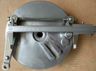 Front brake plate exterior with brake arms set parallel to one another.