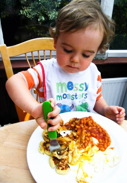 toddler eating tattie scones  with baked beans and eggs