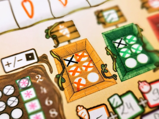 gry roll and write wykreślanki zdjęcie przedstawia zbliżenie na planszę a dokładniej na skrzynkę z marchewkami, na której mamy zaznaczone niewykorzystane pomarańczowe kostki