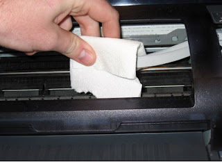 hombre limpiando la impresora - hombre limpiando una impresora - limpiando una impresora - limpieza de una impresora, impresora viejita, vieja impresora, la mano de un hombre, hombre limpiando, hombre con un paño en la mano