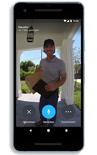 Ein Handy mit einem Bild eines Paketlieferanten vor der Tür – aufgenommen mit Google Nest
