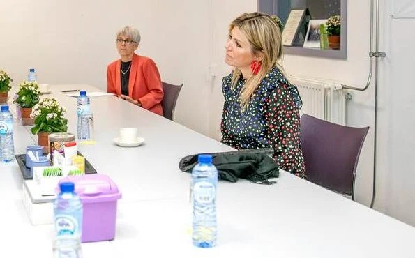 Queen Maxima wore a mixed ditsy floral tiered midi dress by Rixo. Gianvito Rossi shoes. She wore red earrings by Bodes and Bode