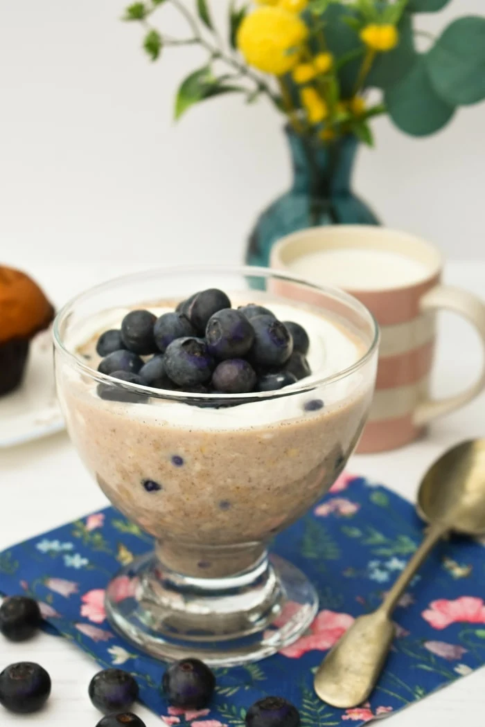 Blueberry Muffin Overnight Oats in a glass topped with yoghurt and more blueberries