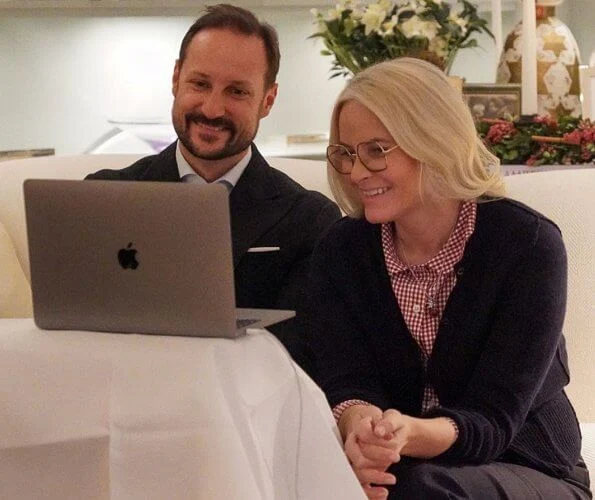 Crown Prince Haakon and Crown Princess Mette-Marit spoke with Kari Elisabeth and Arne Hovengen. navy sweater and red white print shirt