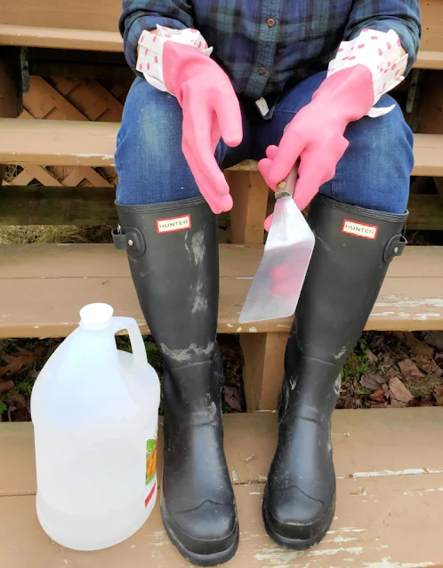 woman sitting on steps wearing rubber boots and rubber gloves