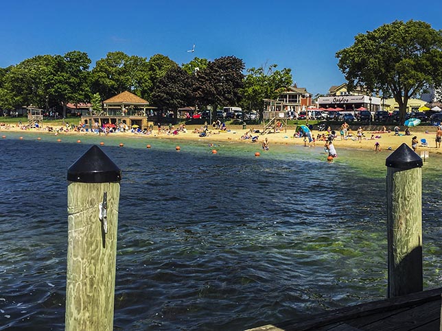 Along the Lake Geneva Lake Shore Path in Lake Geneva Wisconsin families playing on the beach in center of town
