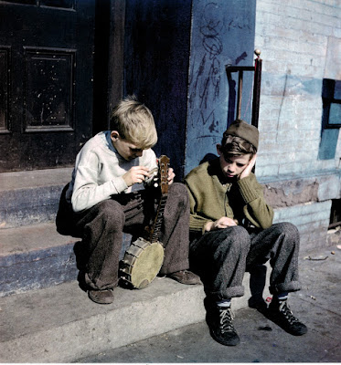 color photogrph of 2 boys with a stringless banjo, East Harlem, 1947