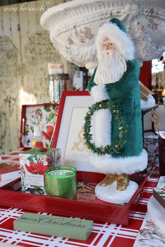 A tall Santa dressed in green velvet holds a Christmas wreath in this year's French Country Christmas Event