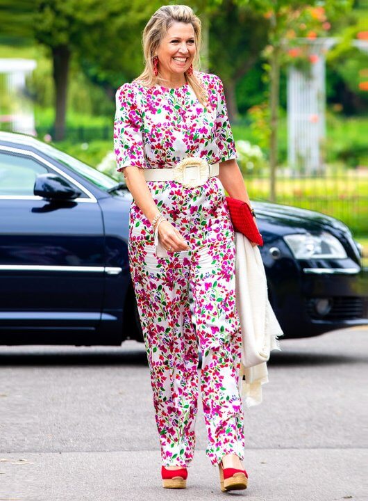 Queen Maxima wore a floral print silk satin half sleeve wide leg jumpsuit from Seren. She wore red wedges from Tory Burch