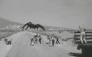 A black and white clip of people running from a giant spider as it comes down the road. From a late 1950s era horror movie.