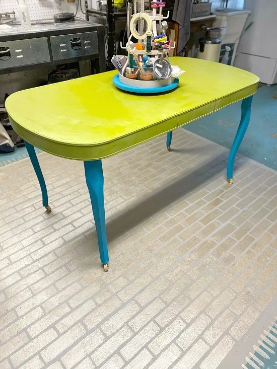 Green and blue painted work table with spinning organizer