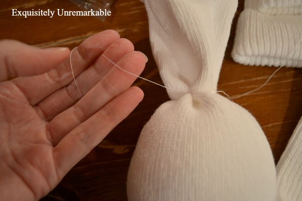 Using Thread To Tie Off The Head Of Sock Angel Using thread to craft a sock angel