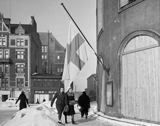 По причине тяжелых условий Мирного договора для Финляндии в знак скорби многие приспустили государственные флаги. Снимок сделан 13 марта 1940 г. на улице Маннергейма в Хельсинки у Шведского театра. Фото: Военный музей Финляндии (SA-kuva).