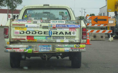 Green Dodge Ram pickup with about two dozen bumper stickers