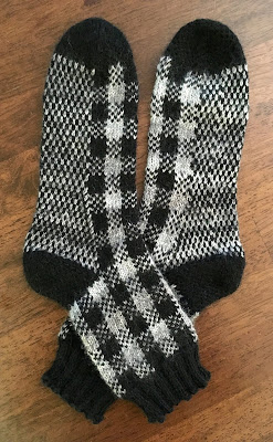 Socks knitted with DROPS Fabel Silver Fox and black in plaid pattern