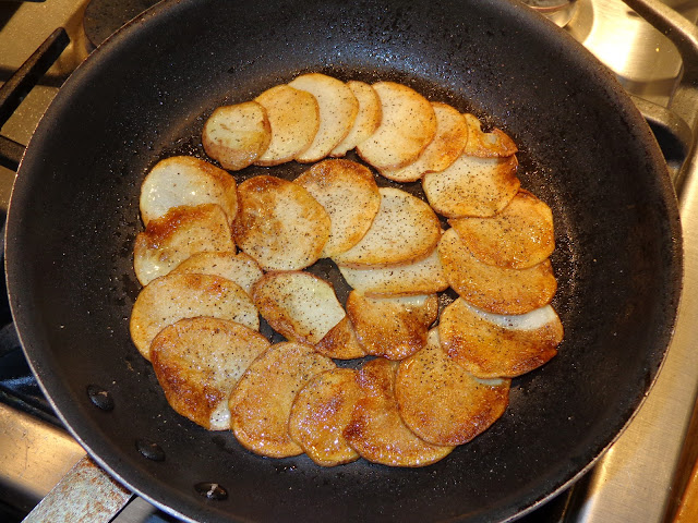 PORTIONS: 2 INGREDIENTS 1 sliced potato with skin on 1 tbsp. olive oil Salt and pepper to taste METHOD Pat dry the sliced potatoes with paper towel. Add olive oil to a nonstick frying pan. Arrange the sliced potatoes, overlapping them around the frying pan. At moderate heat brown the potatoes. Place a flat plate or the flat bottom of a baking pan for cakes and turn around the frying pan leaving the potatoes on the plate with brown side on top. Push the potatoes into the frying pan and brown them. Season it with salt and pepper. To remove the potatoes place a flat plate on top the potatoes and turn the frying pan over again. 