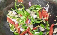 Stir frying vegetables like capsicum, bell peppers and onions for chicken hakka noodles recipe