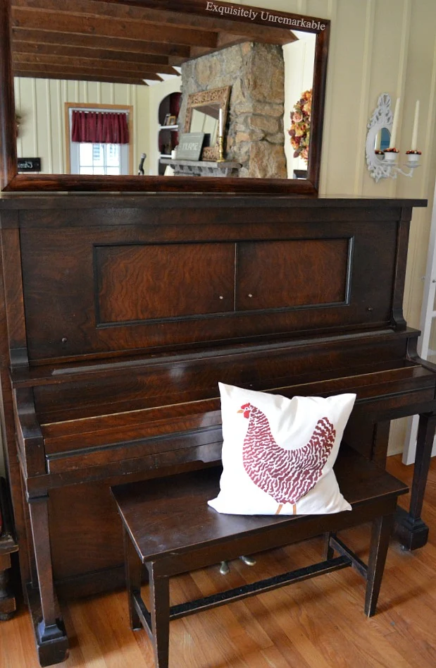 Upright Player Piano Cable Nelson in a living room with rooster pillow on bench