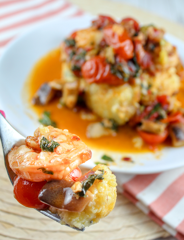 This Shrimp and Grits with Spinach & Tomatoes is a dish that will impress your friends and family! It is as delicious as it is beautiful! These cheesy grit cakes are smothered with jumbo shrimp, sauteed mushrooms, tomatoes and spinach. 
