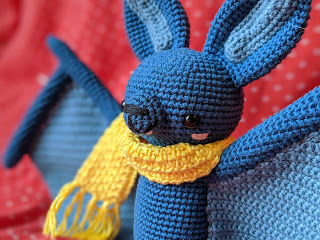 Crocheted blue bat with a yellow scarf
